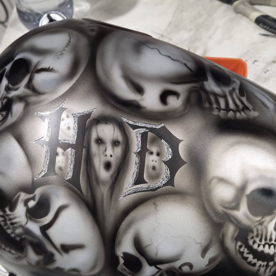 Freehand skull artwork airbrushed onto a Harley-Davidson tank